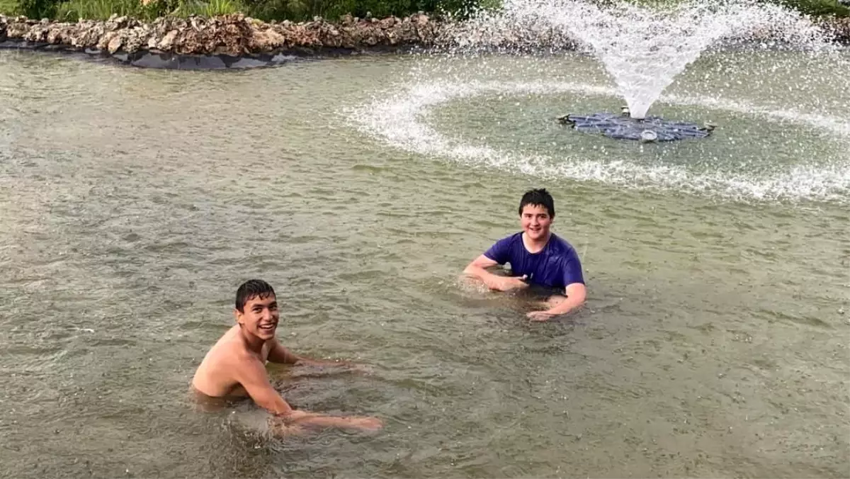 Gençlerin sağanak yağmur altında süs havuzu keyfi
