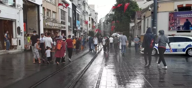 Kısıtlamasız ilk pazar günü Taksim'e gelen vatandaşlar yağmura yakalandı