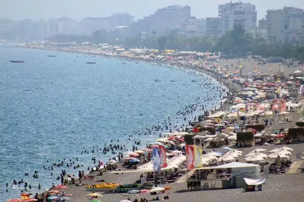 KONYAALTI SAHİLİ DOLDU TAŞTI; UYARI LEVHALARINI DİKKATE ALMAYIP TEHLİKELİ ATLAYIŞ YAPTILAR