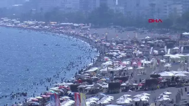 KONYAALTI SAHİLİ DOLDU TAŞTI; UYARI LEVHALARINI DİKKATE ALMAYIP TEHLİKELİ ATLAYIŞ YAPTILAR