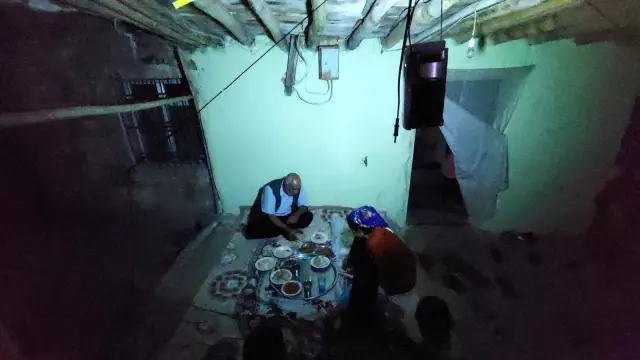 Elektriklerin 4 saat kesildiği köyde seyyar lambanın ışığında yemek yiyorlar