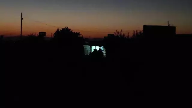 Elektriklerin 4 saat kesildiği köyde seyyar lambanın ışığında yemek yiyorlar