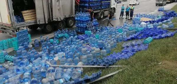 TIR DORSESİNDEN KAYAN YÜZLERCE DOLU DAMACANA YOLA DEVRİLDİ
