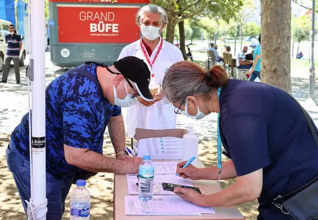 İzmir'de meydanlarda kurulan aşılama noktalarında vatandaşlar hem aşılarını oluyor hem bayramlaşıyor