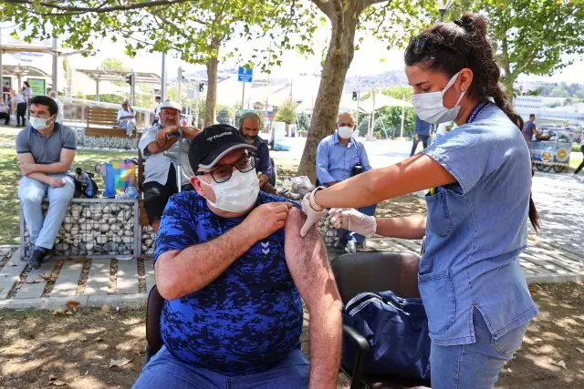 İzmir'de meydanlarda kurulan aşılama noktalarında vatandaşlar hem aşılarını oluyor hem bayramlaşıyor