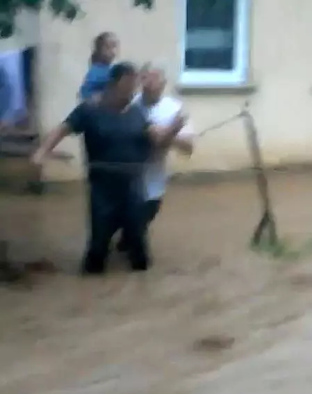 Evden yola ip çekerek dere gibi akan suyun içerisinden geçtiler