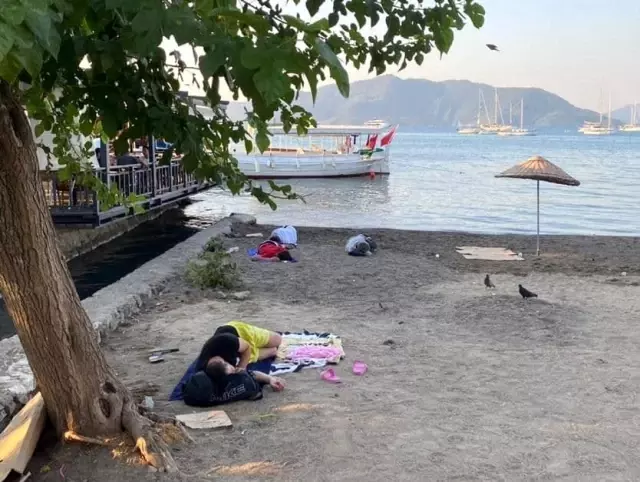 Uyarıları dikkate almayan turistler sahilde uyuyor