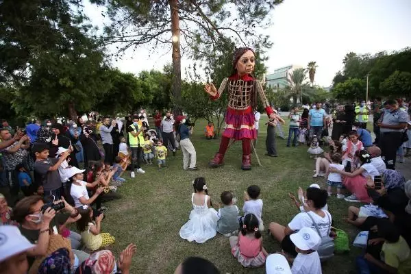 Little Amal walked along while refugee children sang songs
