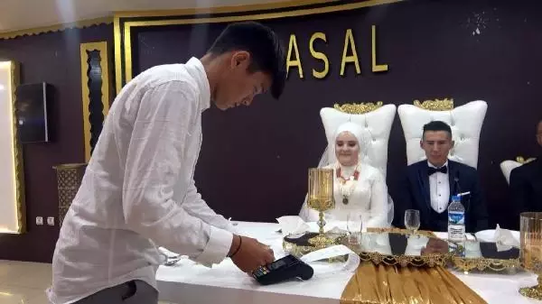 Kırgız çiftin düğününde aşıya dikkat çekmek için pos cihazıyla takı takıldı