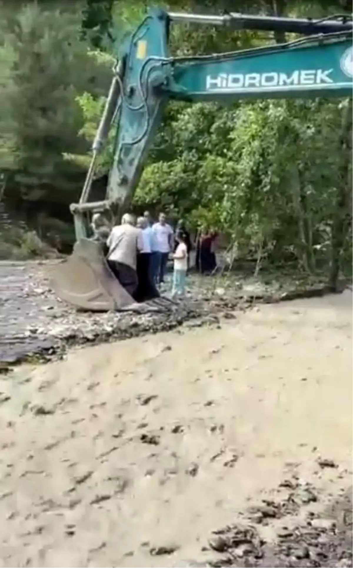 Çayın karşısına geçmeye isteyen vatandaşları kepçe taşıdı