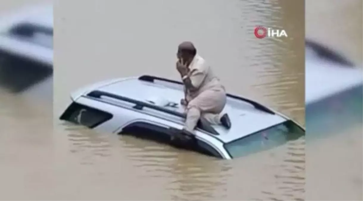 Hindistan'da selde mahsur kalan sürücü aracının üzerinde kurtarılmayı bekledi