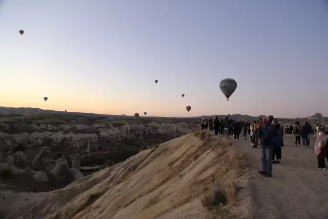Kapadokya'da balonları izlemek isteyen turistler tepelere akın ediyor
