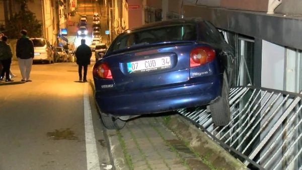 Kadıköy'de demir korkulukları aşan otomobil binanın duvarına çarparak asılı kaldı