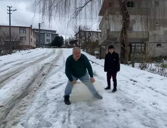Çocukların kar keyfini bozmayan kepçe operatörü onlarla kayarak eğlendi