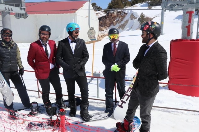 Kadro elbise, kravat ve papyonla Ergan Dağı'nda snowboard keyfi yaptılar