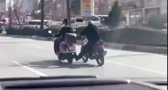 Akan trafikte motosiklet sürücüsü bir diğer motosiklet sürücüsünü ayağıyla itmeye çalıştı