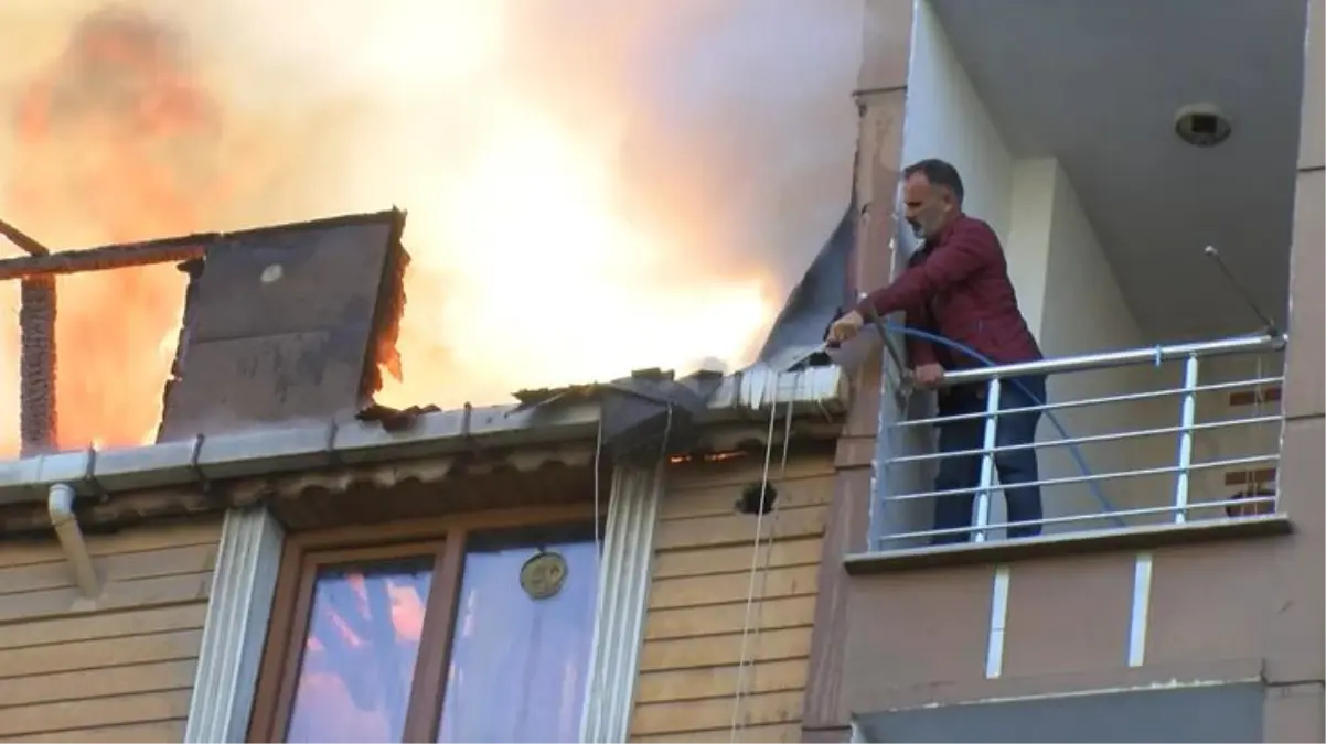 Alev alev yanan çatıyı, balkondan bahçe hortumuyla söndürmeye çalıştı