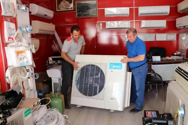 İki erkeğin zor taşıdığı 50 kiloluk klima motorunu tek başına çalan kadın kamerada