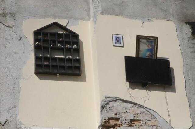 Hatay'ın merkezinden ilginç görüntü... Enkazın ardından televizyon, raf ve ailenin fotoğrafı yan binanın duvarında asılı kaldı Hatay'ın merkezinden ilginç görüntü... Enkazın ardından televizyon, raf ve ailenin fotoğrafı yan binanın duvarında asılı kaldı