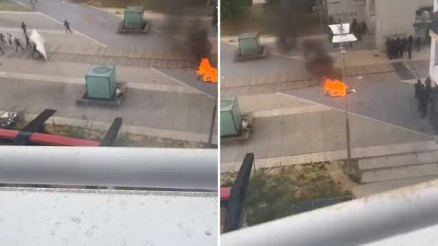Fransa'da polis ve protestocuların çatısması arasında kalan bir kişi, hiçbir şey olmamış gibi sandviç yedi