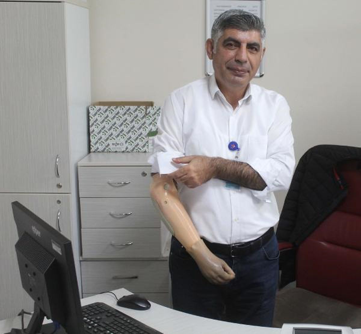 Ampute bir memur, tek eliyle hastalara yardımcı oluyor