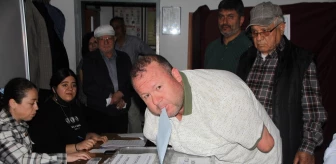 Antalya'da kolları olmayan engelli Bülent Bodur, oy zarfını ağzıyla sandığa attı