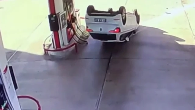 The car, which entered the gas station by flipping over, stopped just before hitting the pump.