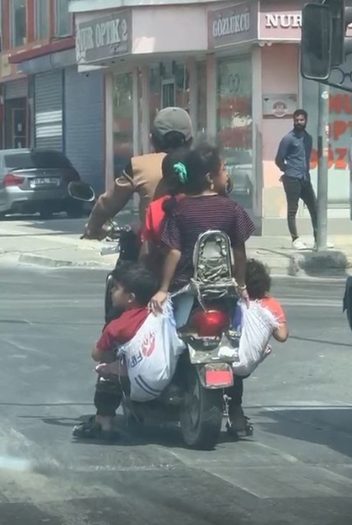Ölümüne rahatlık! Çocuklarını motosiklete astığı çuvallara koydu