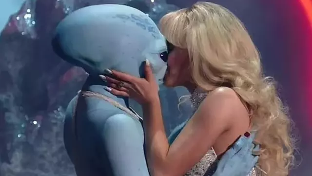 Singer Sabrina Carpenter surprised the audience by kissing a dancer wearing a blue alien costume on stage.