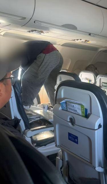 Passenger attempting to break the airplane seat by kicking it was subdued by other passengers