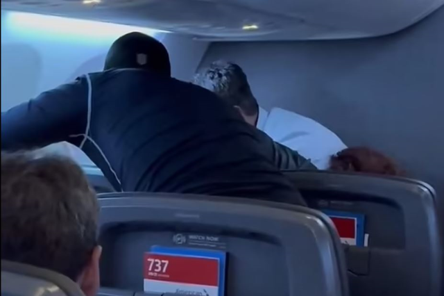 Passenger attempting to break the airplane seat by kicking it was subdued by other passengers