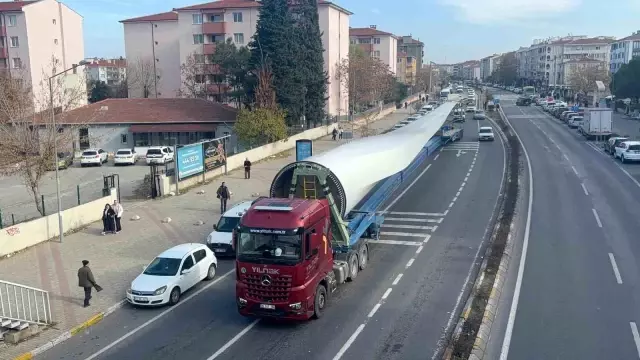 The giant wind turbines passed among the curious gazes of the citizens