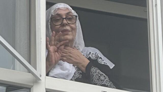 Necla Nazır, unable to resist the insistence of reporters, came out to the window to accept condolences