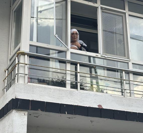 Necla Nazır, unable to resist the insistence of reporters, came out to the window to accept condolences