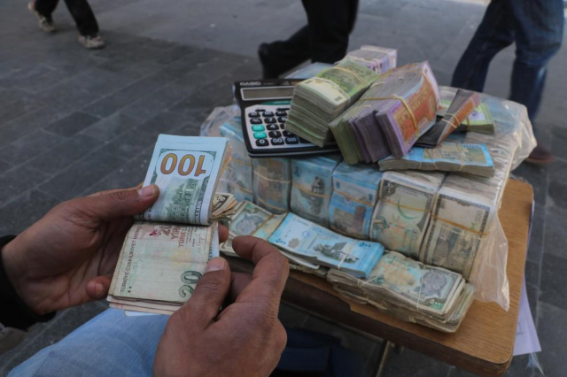 Money changers are exchanging bundles of money on the streets of Syria