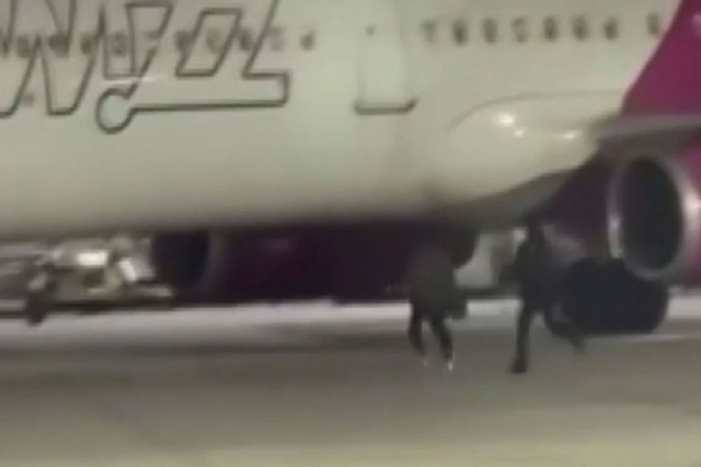 The two passengers who missed their flight broke the glass of the emergency exit door and jumped onto the runway