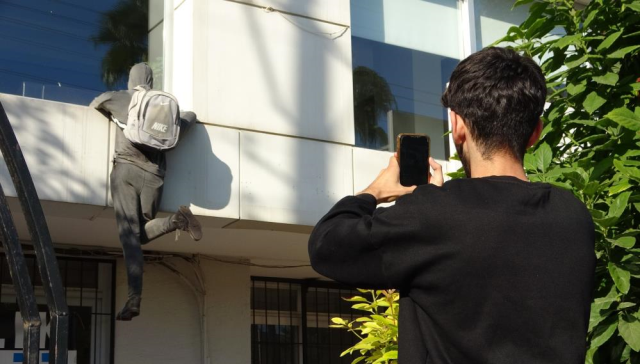 Those who see the lifeless mannequin 'thief' in the window are calling the police and throwing stones