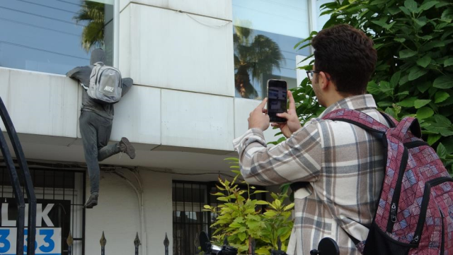 Those who see the lifeless mannequin 'thief' in the window are calling the police and throwing stones