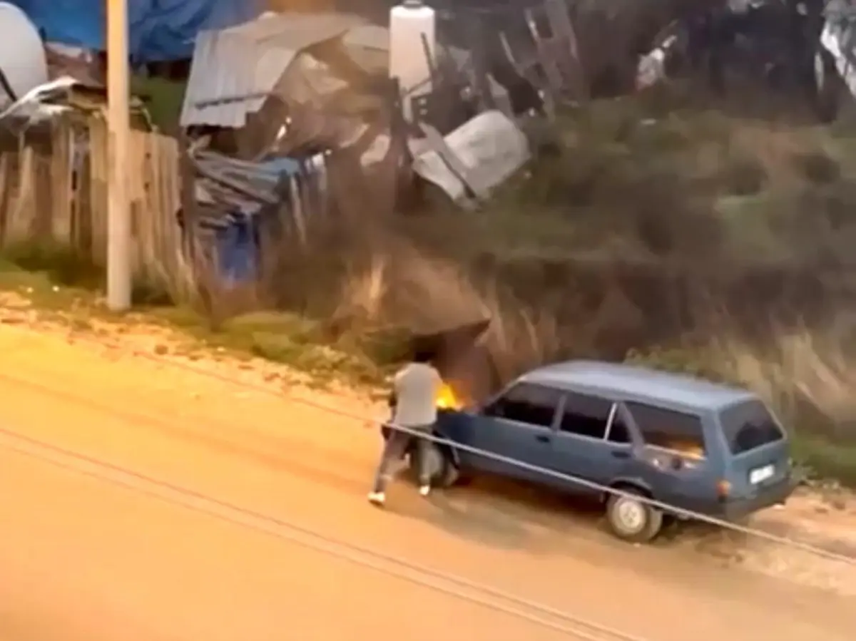Alev alev yanan aracını kovayla su döküp söndürdü