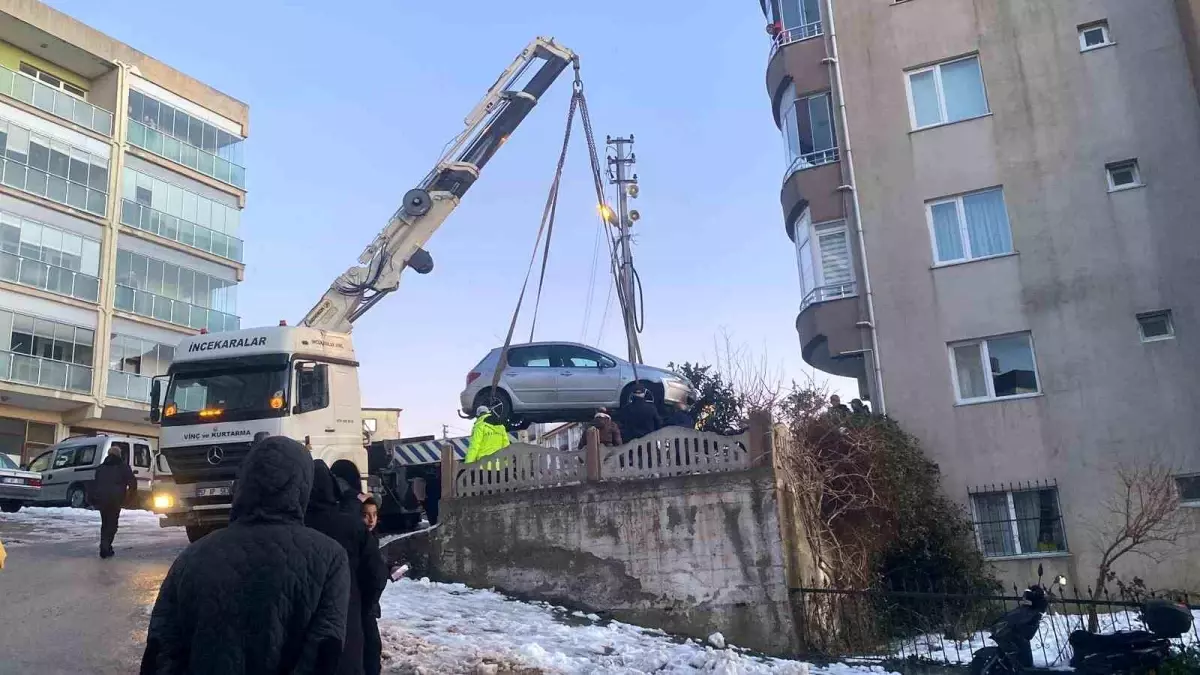Buzlanan yolda kayan otomobil apartmanın bahçesine düştü