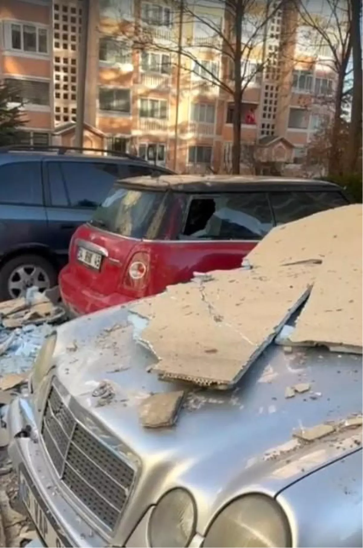 Şiddetli fırtınadan dolayı sökülen dış yalıtım malzemeleri üzerine düştükleri otomobillerin hasar almasına...