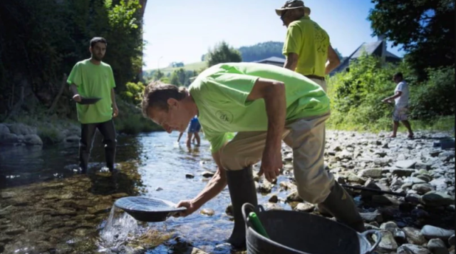 Gold is revealed in the riverbed, those who take their pans collect handfuls
