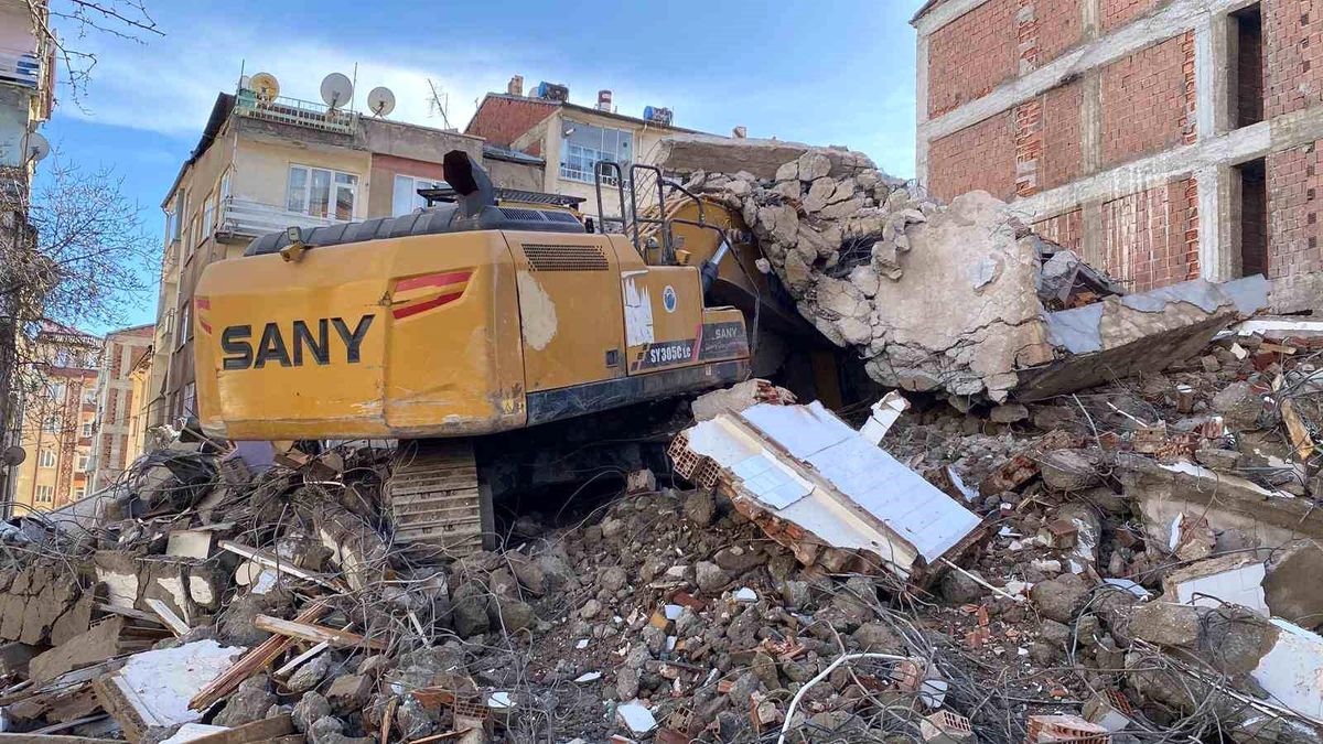 Ağır hasarlı binanın enkazı iş makinesinin üstüne yıkıldı