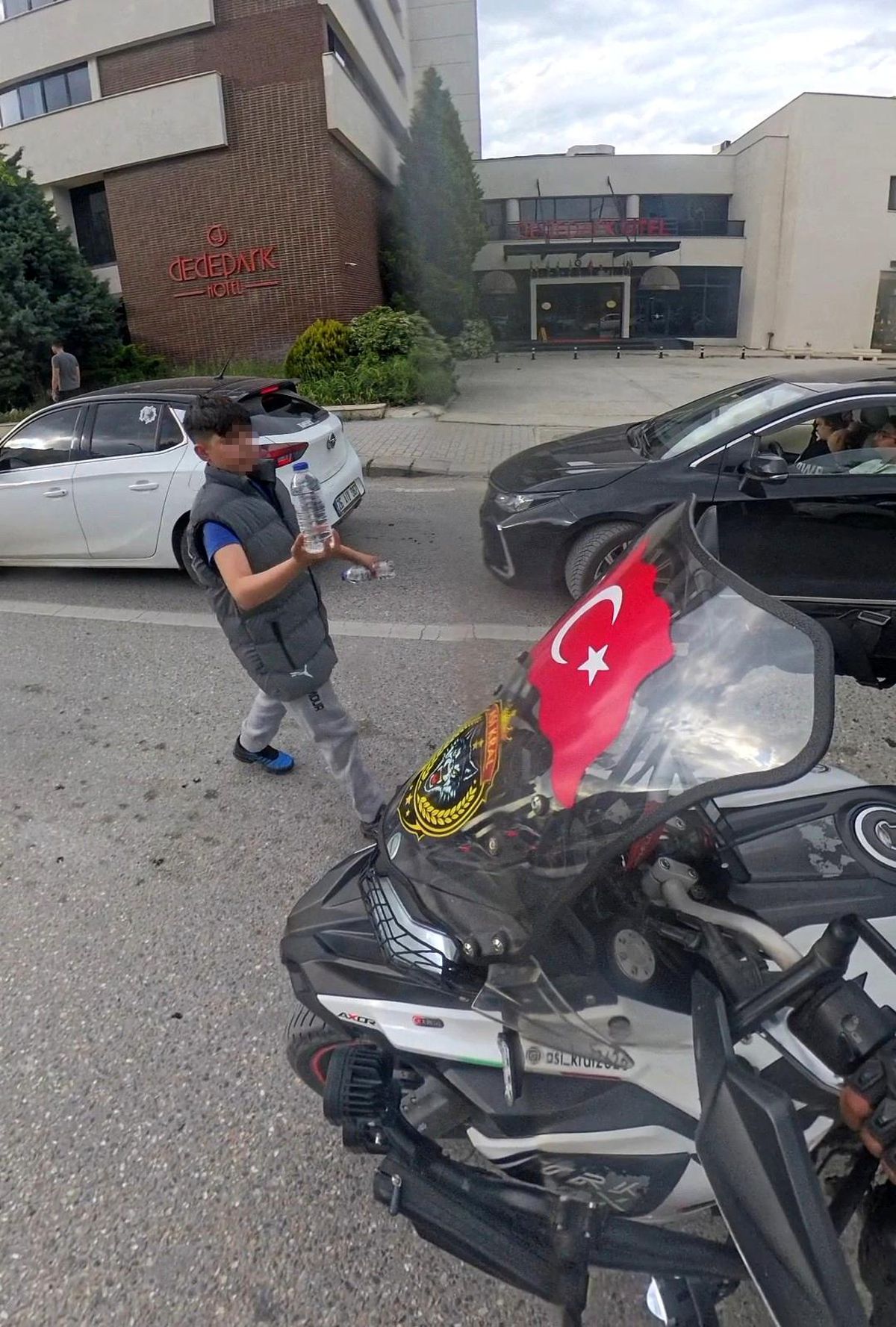 Su satan çocuk, camında Türk bayrağı olan motosikletliye su hediye etmek istedi
