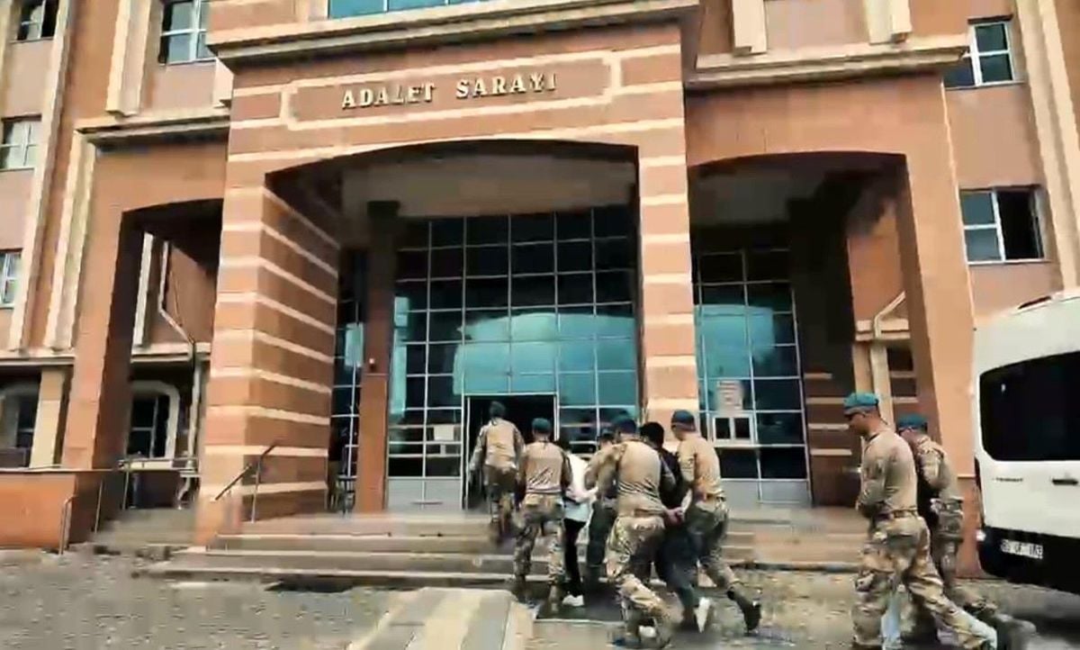 Osmaniye'de siber dolandırıcılık operasyonu kapsamında gözaltına alınan şüpheliler emniyet binasına getirilirken çekilmiş bir fotoğraf.