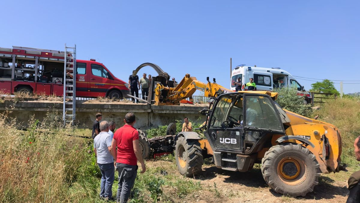 Köprüden düşen traktörün altında kalan sürücü iş makinesiyle