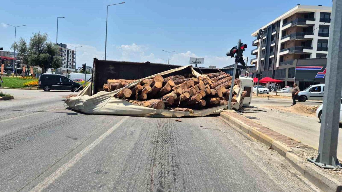 Kamyon kavşağa girerken devrildi, tomruklar yola savruldu