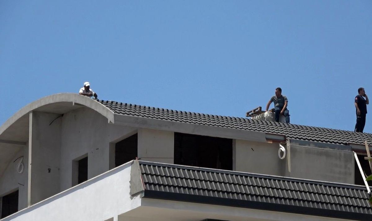 Alanya'da bir binanın çatısında duran bir şahıs, polis tarafından ikna ediliyor.
