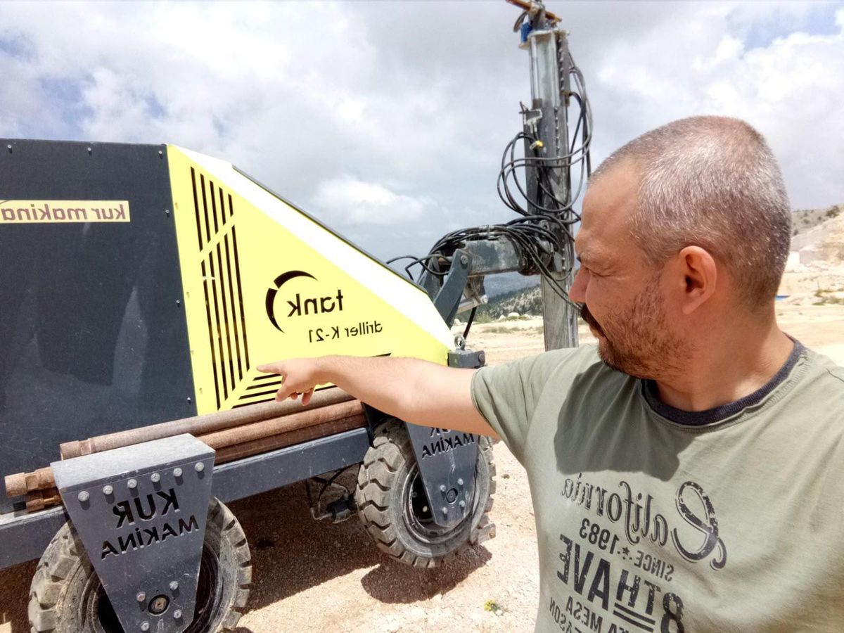 Sanayi tesisinde kurulu hibrit enerji sistemi bileşenleri: güneş panelleri, batarya ünitesi ve kontrol paneli.