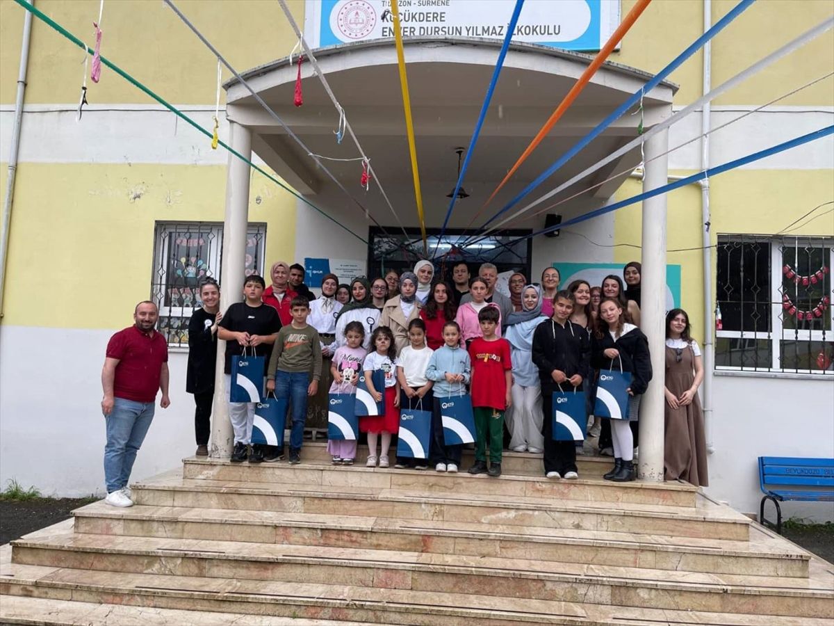 Karadeniz Teknik Üniversitesi öğrencileri Sürmene'deki ilkokulda çocuklara yardım dağıtırken